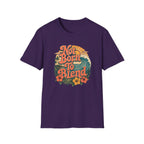 A purple short-sleeve crewneck t-shirt featuring a retro circular graphic on the chest with the text 'Not Born To Blend' in orange, surrounded by a sunset, palm tree, waves, and hibiscus flowers.