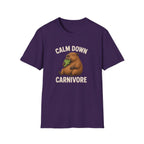A purple short-sleeve crewneck t-shirt featuring a cartoon groundhog graphic holding green lettuce, with the text 'CALM DOWN CARNIVORE' printed in beige above and below the illustration.