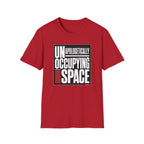 A red short-sleeve crewneck t-shirt with a black and white graphic print on the front reading 'UNAPOLOGETICALLY OCCUPYING SPACE' alongside red equalizer bars, shown on a plain white background.