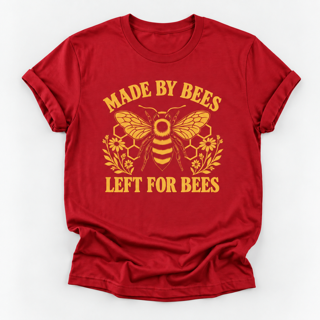A red short-sleeve crewneck t-shirt with a yellow graphic print featuring a bee, honeycomb, flowers, and the text 'MADE BY BEES LEFT FOR BEES' on a light gray background.