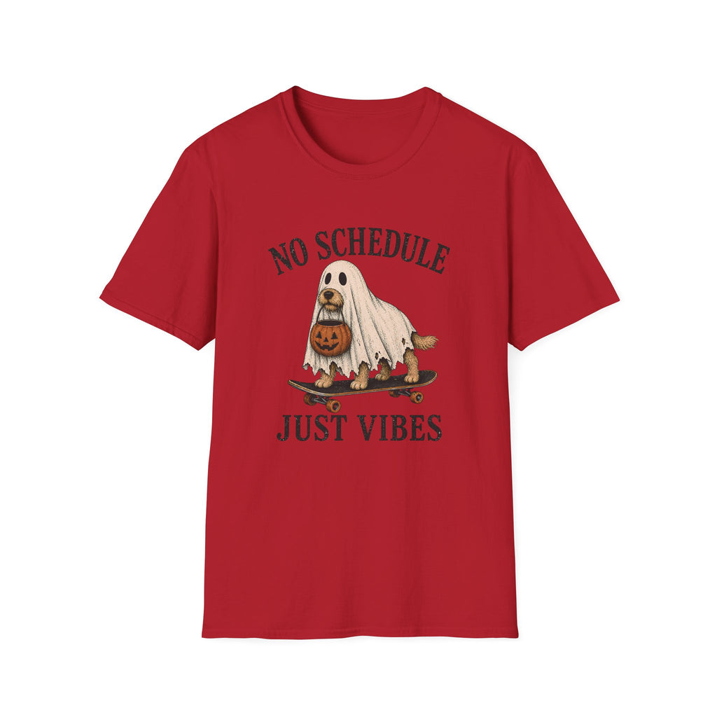 A red short-sleeve crewneck t-shirt featuring a Halloween graphic of a ghost riding a skateboard with a jack-o'-lantern, with the text 'NO SCHEDULE JUST VIBES' printed in black.