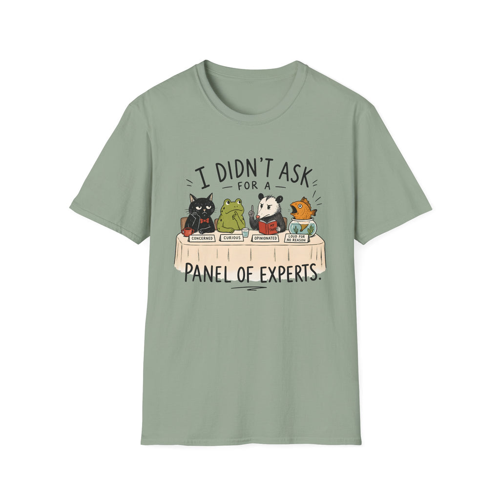 A sage green short-sleeve crewneck t-shirt featuring a cartoon graphic of four animals (a cat, frog, panda, and turtle) sitting at a table with the text 'I DIDN'T ASK FOR A PANEL OF EXPERTS.'.