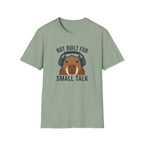 Sage green  t-shirt with image of a capybara wearing headphones and text 'not built for small talk'