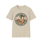 A sand colored crewneck t-shirt featuring a circular retro graphic on the chest with the text 'SURVIVED THE HYPOTHETICAL ISLAND' and an illustration of a woman and dog on a beach under a palm tree.
