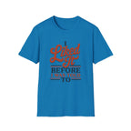 A bright blue short-sleeve crewneck t-shirt with a retro-style graphic on the chest that reads 'I Liked It BEFORE I WAS TOLD TO' in orange and navy blue lettering, displayed on a solid white background.