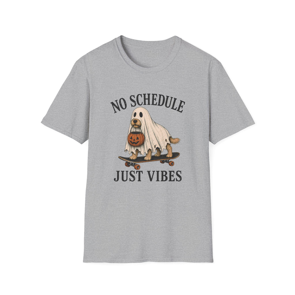 A light gray short-sleeve crewneck t-shirt featuring a Halloween graphic of a dog dressed as a ghost on a skateboard with a pumpkin, with the text 'NO SCHEDULE JUST VIBES' printed in black.