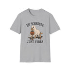 A light gray short-sleeve crewneck t-shirt featuring a Halloween graphic of a dog dressed as a ghost on a skateboard with a pumpkin, with the text 'NO SCHEDULE JUST VIBES' printed in black.