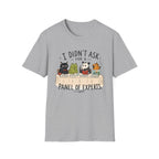 A light heather gray short-sleeve crewneck t-shirt featuring a cartoon graphic of five animals (a black cat, green frog, panda, orange cat, and mouse) sitting at a table with books, with the text 'I DIDN'T ASK FOR A PANEL OF EXPERTS.' printed above and below.