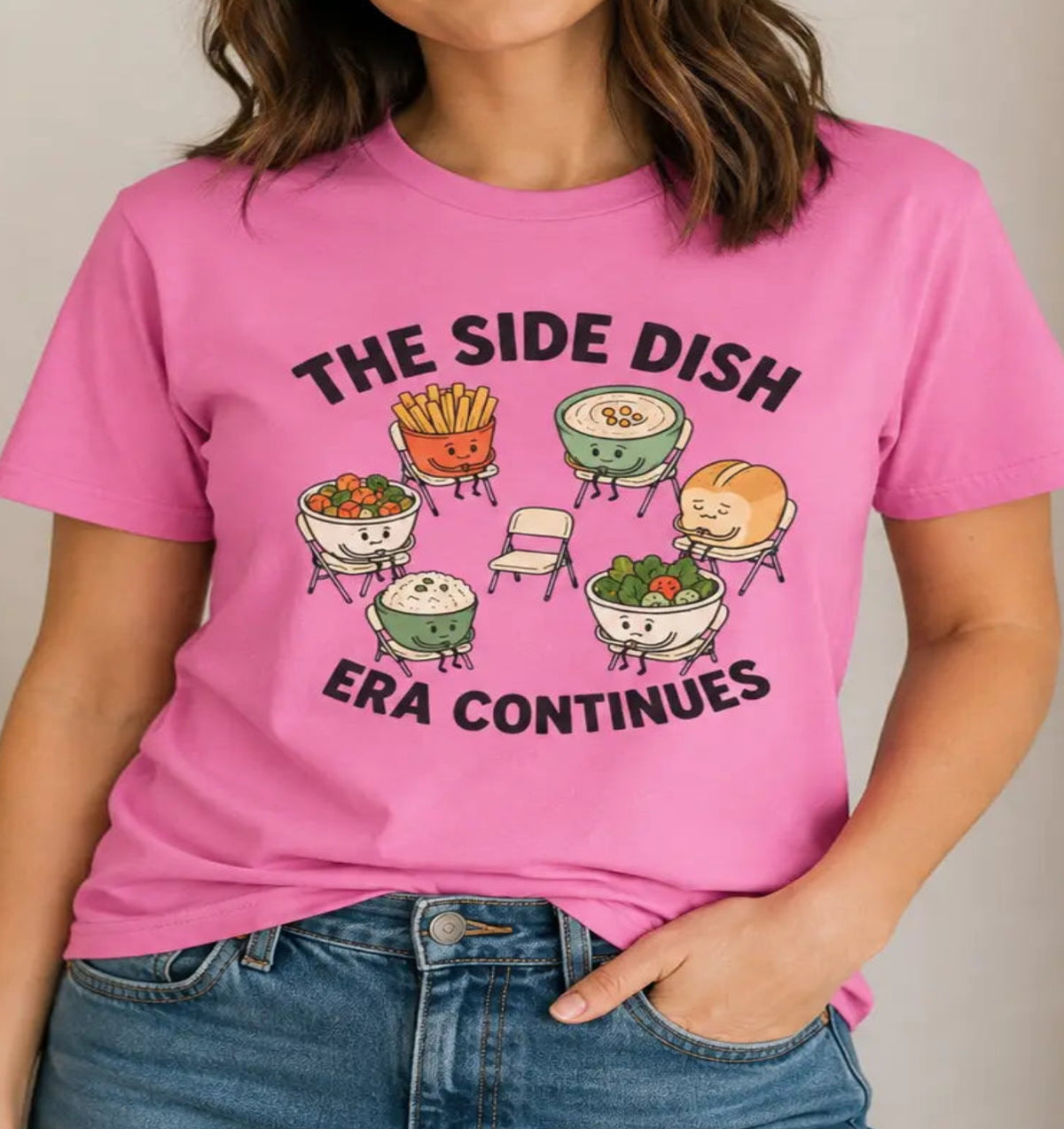 Woman wearing a vegan pink t-shirt with text 'the side dish era continues' with various side dishes sitting in a circle