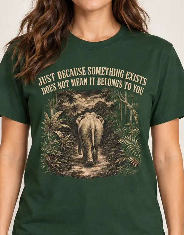 Dark Green t-shirt with an elephant graphic in the jungle and text 'just because something exists doesn't mean it belongs to you'