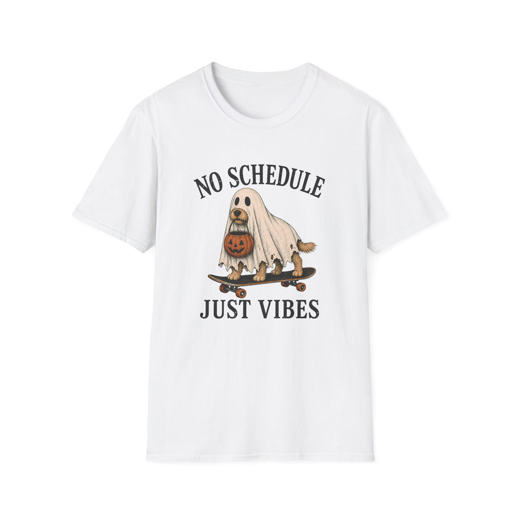 A white short-sleeve crewneck t-shirt featuring a cartoon graphic of a dog dressed as a ghost on a skateboard with a pumpkin, with the text 'NO SCHEDULE JUST VIBES' printed in black.