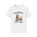 A white short-sleeve crewneck t-shirt featuring a cartoon graphic of a dog dressed as a ghost on a skateboard with a pumpkin, with the text 'NO SCHEDULE JUST VIBES' printed in black.