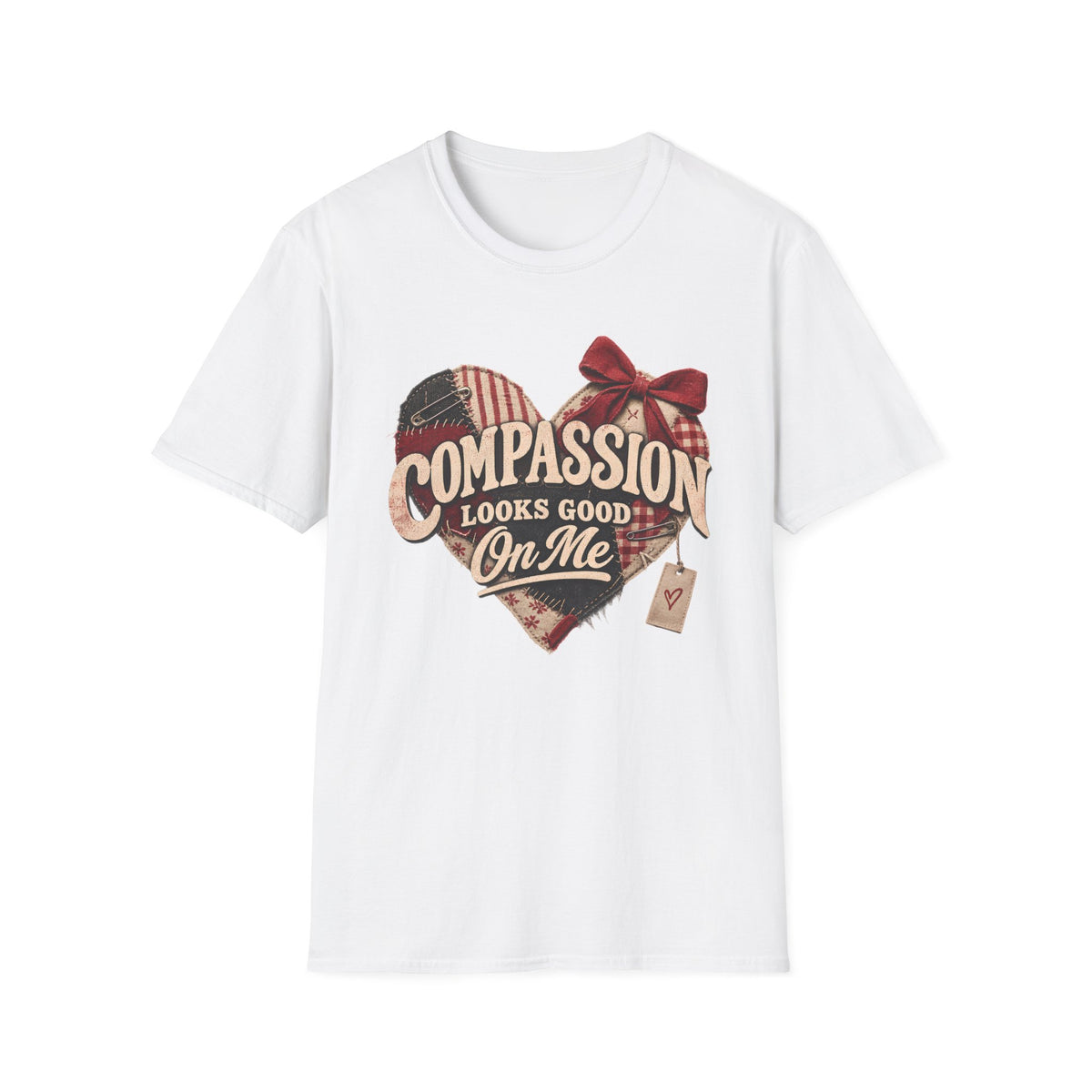 A white short-sleeve crewneck t-shirt featuring a rustic heart-shaped graphic with a red bow, plaid pattern, and the text 'COMPASSION LOOKS GOOD ON ME' in a vintage font.
