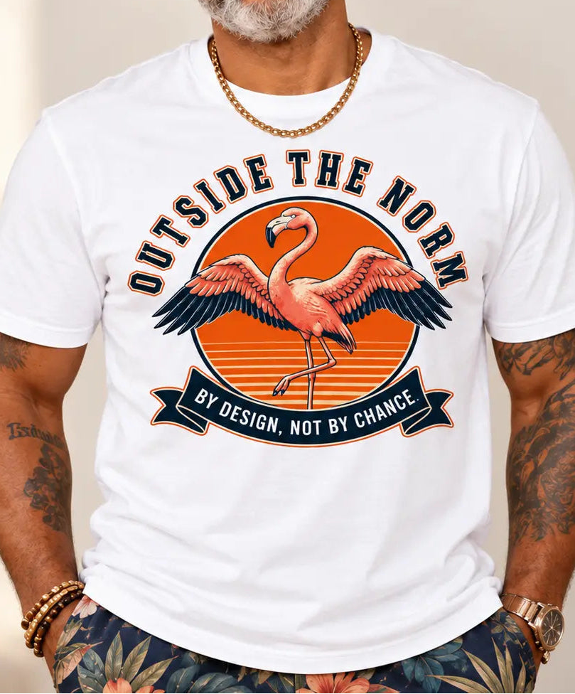 A man wearing a white graphic t-shirt with a flamingo design and the text 'OUTSIDE THE NORTH BY DESIGN, NOT BY CHANCE', styled with a tan hat, sunglasses, and patterned shorts.