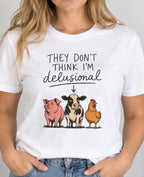 woman wearing a white t-shirt with farm animals and text 'they don't think i'm delusional'