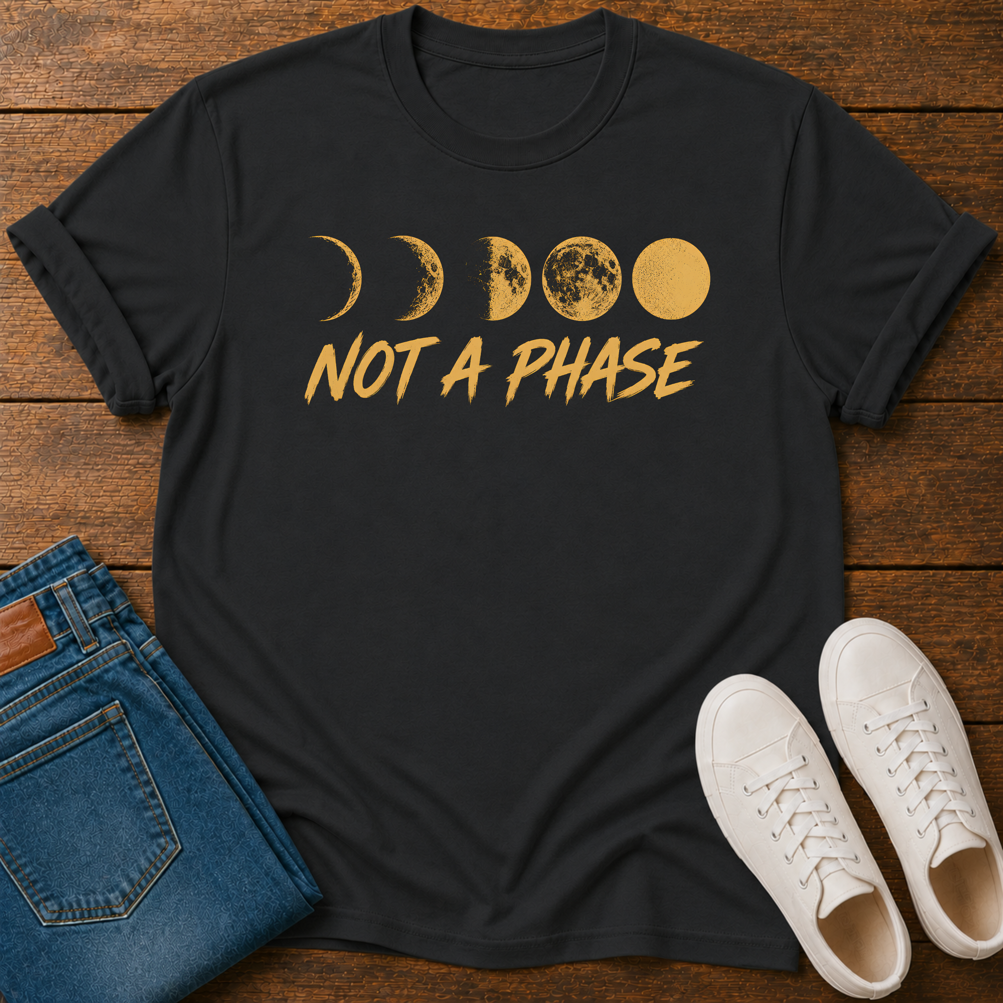 Not A Phase graphic t-shirt design with gold moon phases and bold lettering on a dark background