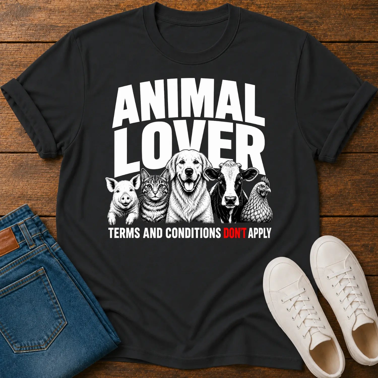Black t-shirt with animal lover graphic on a wooden surface with jeans and shoes.