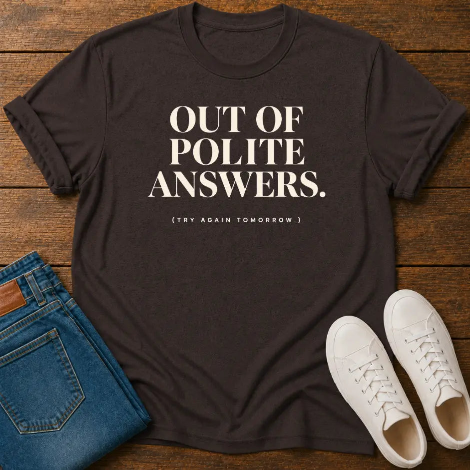 A dark charcoal gray graphic t-shirt with the text 'OUT OF POLITE ANSWERS. (TRY AGAIN TOMORROW)' printed in white.