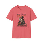 A coral pink short-sleeve t-shirt with a Halloween graphic of an opossum wearing a witch hat and holding a candy corn, with the text 'HERE FOR THE CANDY. NOT THE PEOPLE.