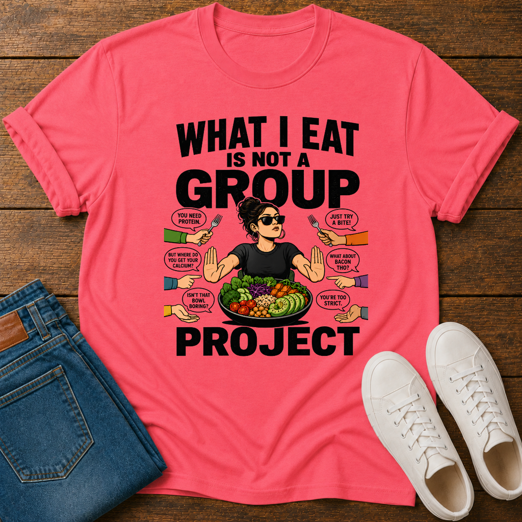 coral t-shirt with a graphic of a woman eating salad and non vegan questions being thrown at her with text 'what i eat is not a group project" on a wooden board with jeans and sneakers
