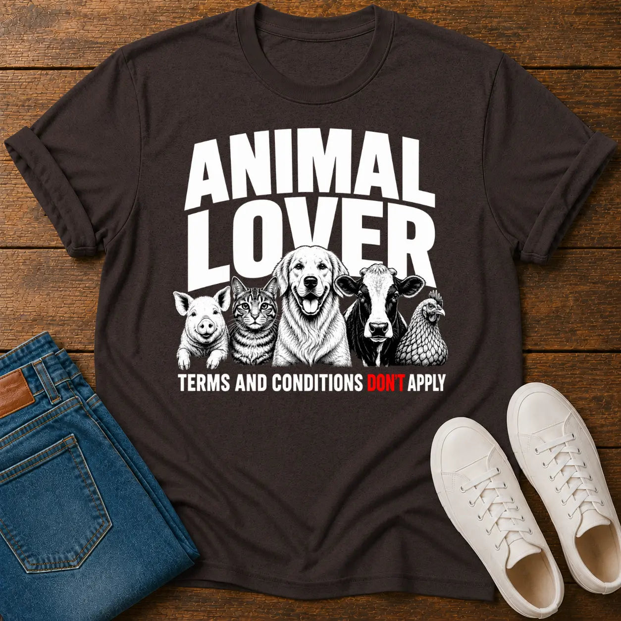 Black t-shirt with 'Animal Lover' graphic on a wooden surface with jeans and shoes.