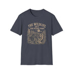 A dark slate blue crewneck t-shirt with a vintage-style beige graphic on the front. The graphic features the text 'THE WILDLIFE ISN'T THE SCARY PART' above an illustration of a moose, raccoon, squirrel, and other forest animals in a pine tree stand.