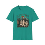 A teal green short-sleeve crewneck t-shirt with a vintage-style Halloween graphic on the chest. The graphic features three ghosts in white sheets, a signpost pointing left, and the text 'LEAVE NO TRACE' above and 'OR WE'LL LEAVE ONE' below.