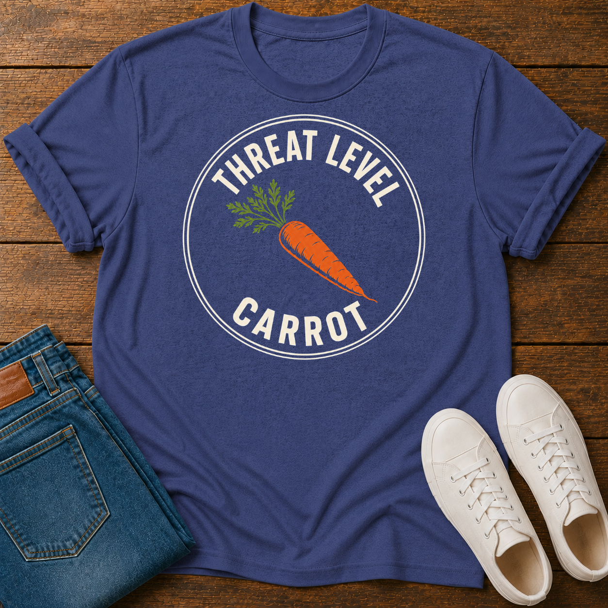 Blue t-shirt with 'Threat Level Carrot' graphic on a wooden surface with jeans and shoes.