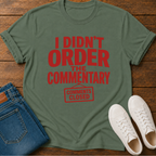Green t-shirt with red text on a wooden surface with jeans and shoes.