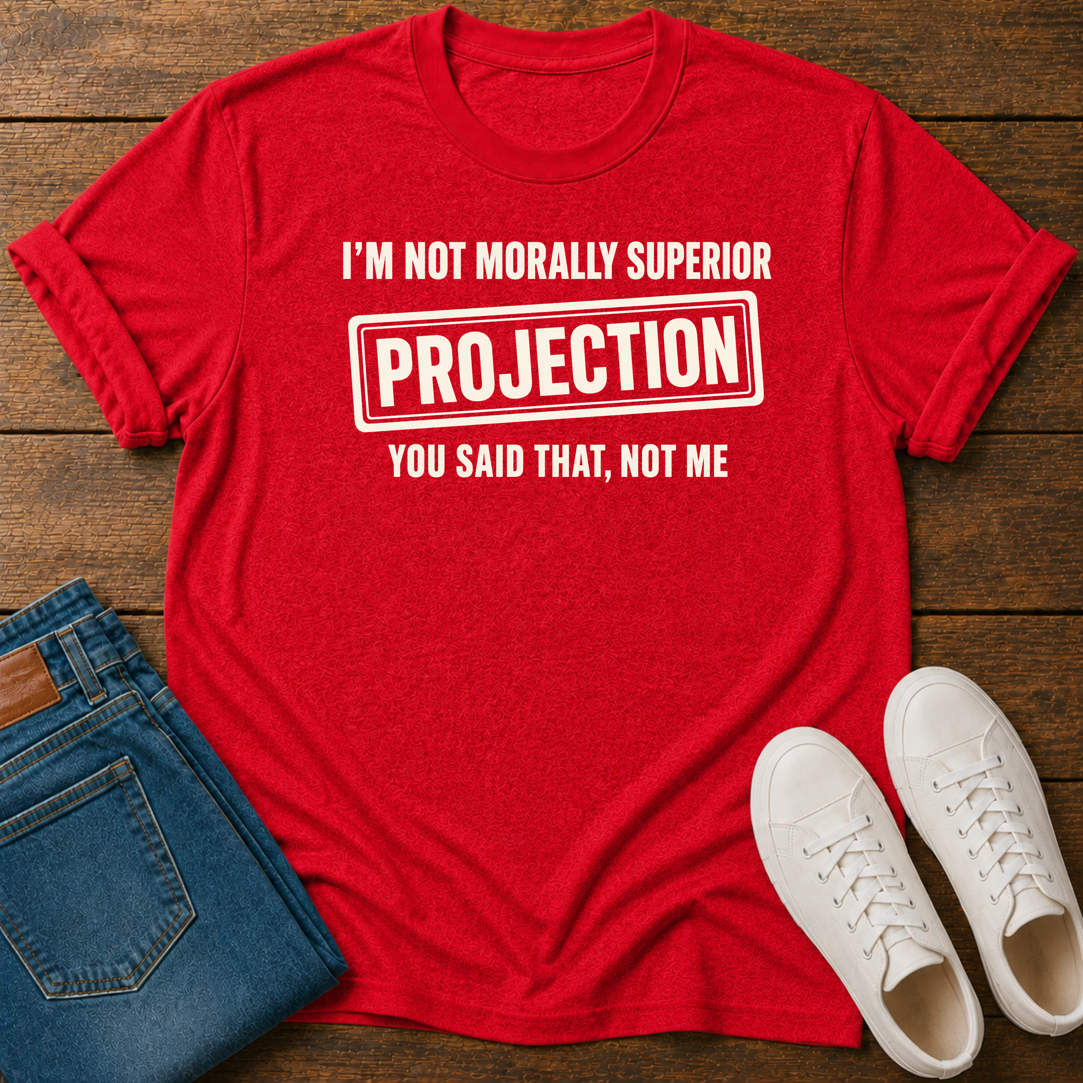 Red t-shirt with vegan slogan i'm not morally superior you said that not me on a wooden board styled with jeans and sneakers.