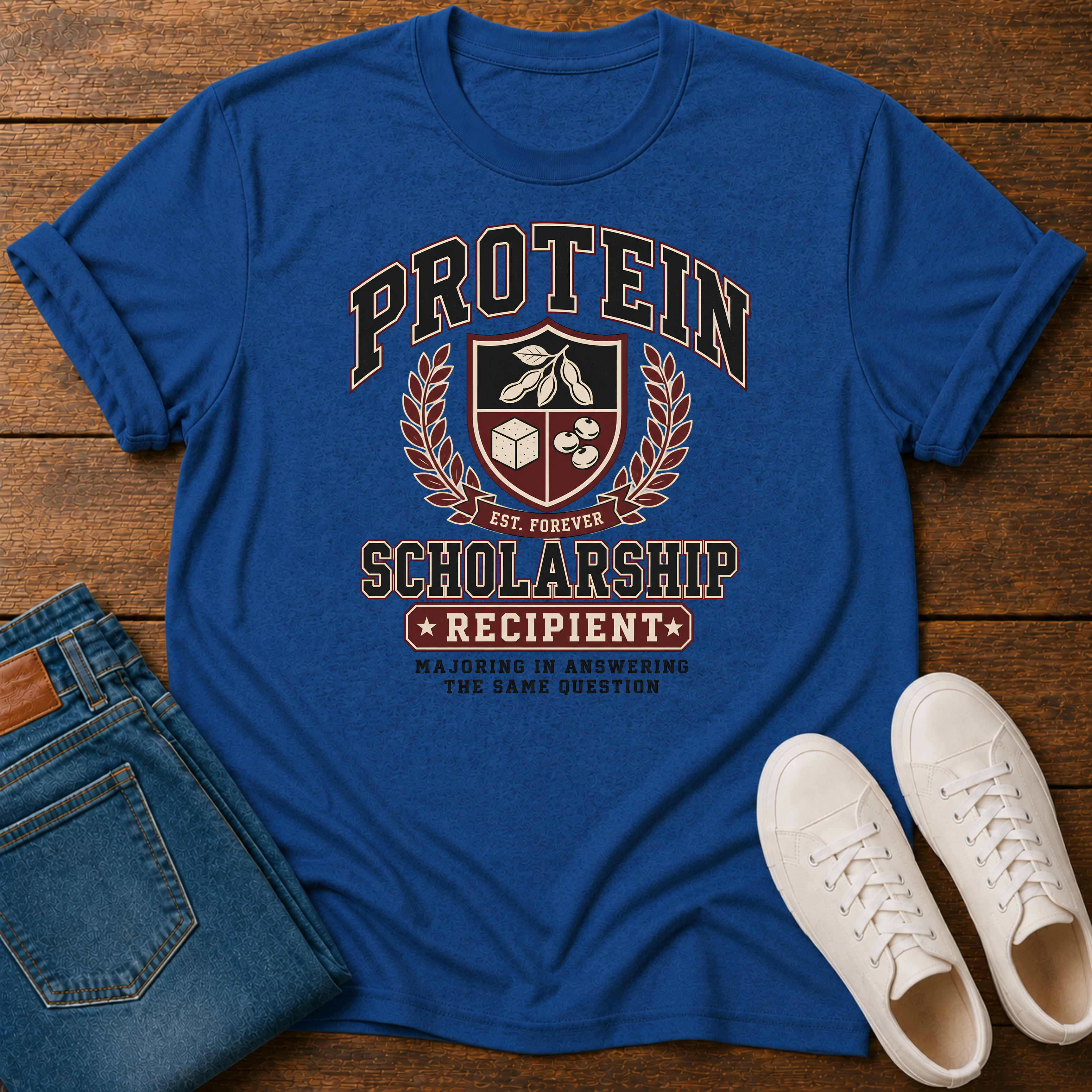 Royal Blue T-shirt with Vintage collegiate crest design reading “Protein Scholarship Recipient” with soybean, tofu, and bean illustrations and the words “Majoring in Answering the Same Question.”