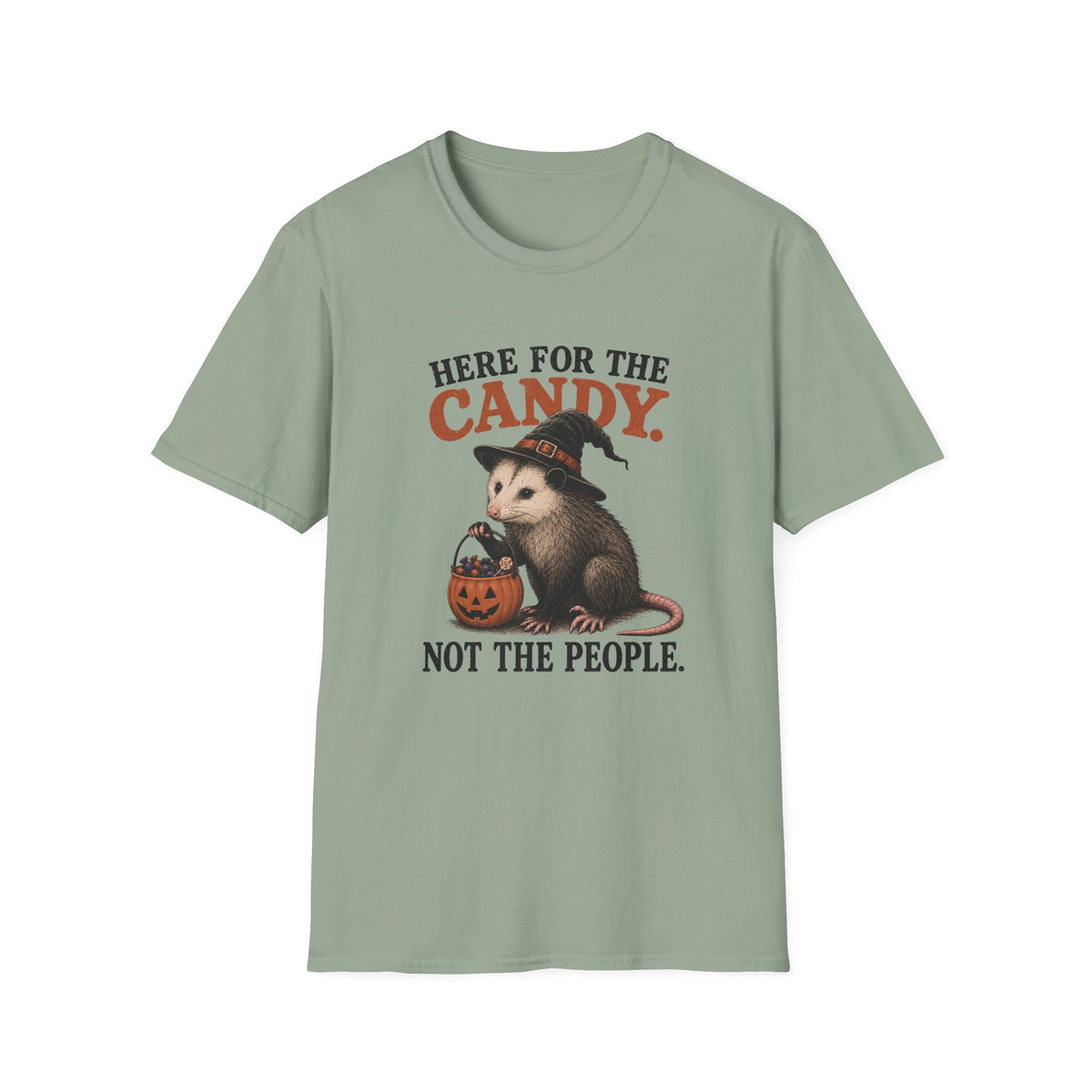 A sage green short-sleeve crewneck t-shirt featuring a Halloween graphic of an opossum in a witch hat holding a jack-o'-lantern, with the text 'HERE FOR THE CANDY. NOT THE PEOPLE.