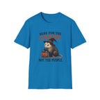 A bright blue short-sleeve crewneck t-shirt featuring a Halloween graphic of an opossum in a witch hat holding a jack-o'-lantern candy basket, with the text 'HERE FOR THE CANDY. NOT THE PEOPLE.