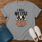 A gray graphic t-shirt featuring a Boston Terrier dog peeking out from behind text that reads 'I ROLL MY EYES AS MUCH AS YOU DO I'M JUST BETTER AT HIDING IT'. The t-shirt is styled in a flat-lay on a wooden background alongside blue jeans and white sneakers.