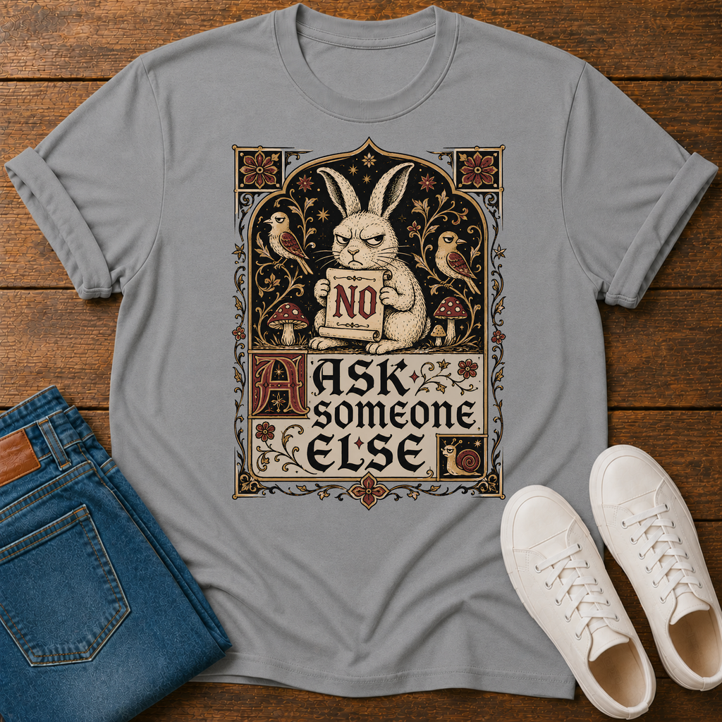 A light gray graphic t-shirt laid flat on a wooden surface, styled with folded blue jeans and white sneakers. The t-shirt features a vintage-style illustration of a rabbit holding a sign that says 'NO' surrounded by birds, mushrooms, and the text 'ASK someone ELSE'.
