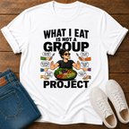 white t-shirt with a graphic of a woman eating salad and non vegan questions being thrown at her with text 'what i eat is not a group project" on a wooden board with jeans and sneakers